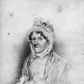 Stipple engraving of Priscilla Wakefield by James Thompson after Thomas Charles Wageman, published 1818. She sits with her hands clasped in her lap, wearing a dress, shawl, and an elaborate cap which encircles her face, leaving a few dark curls visible. Her name is written in italics below.